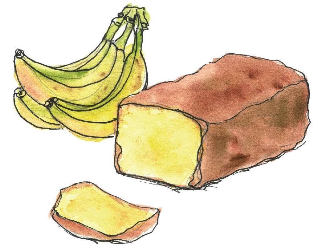 loaf of banana bread beside bunch of fresh bananas.